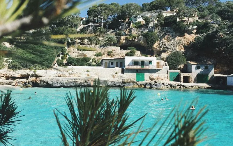 Turquoise cala framed by pine branches, Mallorca