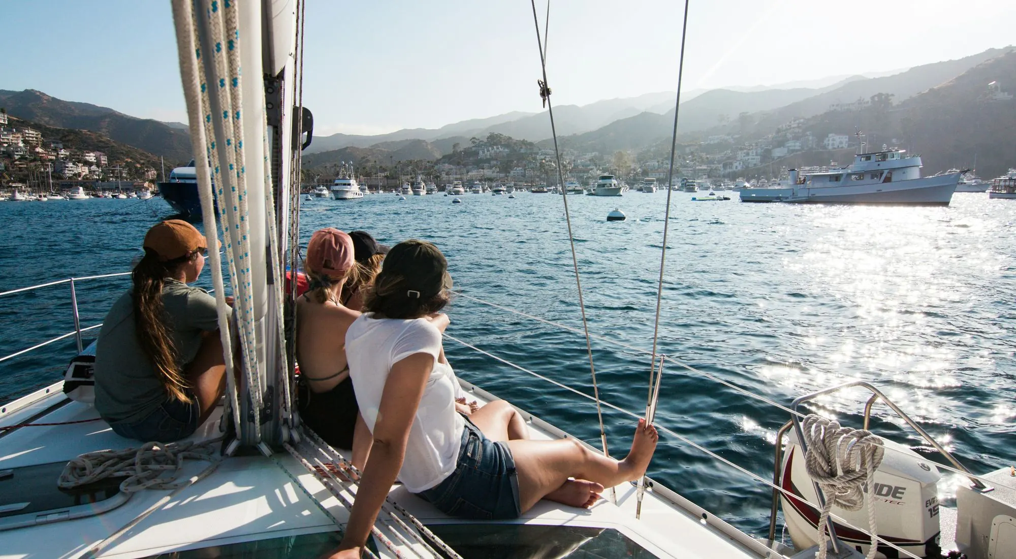 Friends relaxing on the bow of a sailboat under sail
